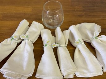 An Assortment Of Styles Of Cotton Napkins With Glass Napkin Holders And A Stay Calm And Hop On Glass