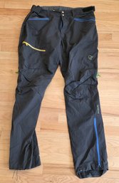 V10 Black Norrna Falketind Flex1 Softshell Pants Featuring Contrasting Blue And Yellow Zippers