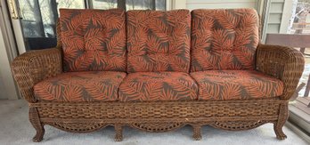 Indoor Wicker Sofa With A Rich Walnut Finish And Custom Cushions Featuring A Tropical Leaf Pattern