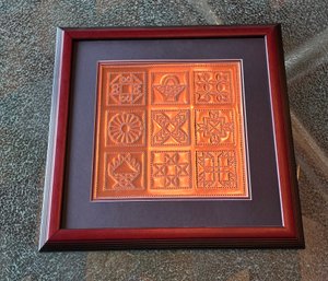 Decorative Metal Wall Art Featuring A Collection Of Embossed Copper Squares In A Framed Display