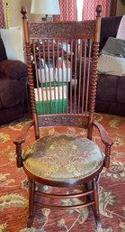 ANTIQUE SPINDLE BACK PADDED ROCKING CHAIR WITH ORNATE FIGURAL LION HEAD ACCENT