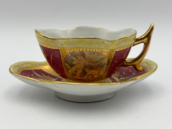 Antique Austrian Demitasse Teacup And Saucer Cerise And Gold Gilt With Cherubs In Panels W/ Wishbone Handle