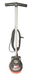 Oreck Commercial Orbiter Floor Machine With A T-handle, Wrapped Power Cord, And An Orange Scrubbing Brush Atta