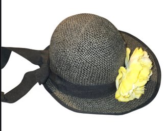 Black Woven Sun Hat With A Yellow Floral Accent.