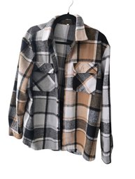 Plaid Flannel Shacket In A Brown, Black, White, And Grey Color Block Pattern.