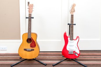 Collection Of Two Kids Guitars, Including A Fender And Yamaha, Both With Stands