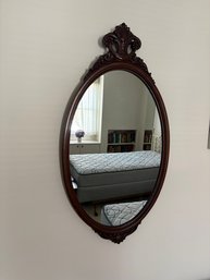 Antique Oval Wall Mirror Featuring A Carved Wooden Frame