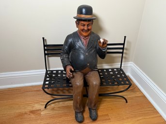 A Vintage Oliver Hardy Statue On A Metal Bench