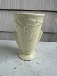 Art Deco Matte Cream Ceramic Vase Featuring An Embossed Leaf Motif And Distinctive Wing Handles