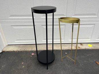 A Tall Black Metal Plant Stand And A Smaller Mustard