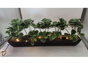 Faux Greenery Centerpiece In Long Dark Planter With String Lights