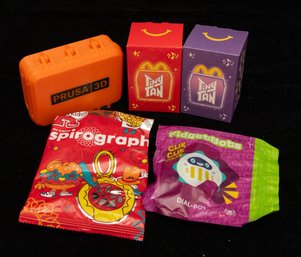 Variety Of Fast-food Kids' Meal Toys And A Miniature Storage Box. These Include Recent Collaborations From McD