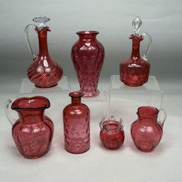 Seven Cranberry Glass Pitchers, Decanters And Vases