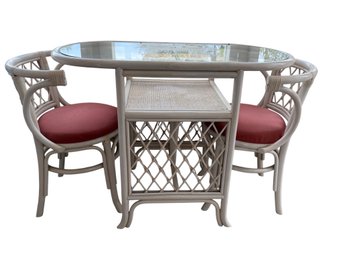 White Rattan Dining Set With Glass Top Table And Four Red-Cushioned Chairs