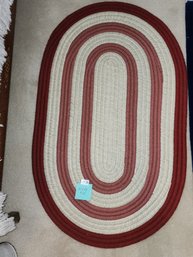 132 - OVAL SHAPED RED AND BEIGE RUG