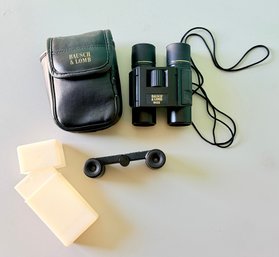 Pair Of Bausch & Lomb Binoculars Alongside A Leather Carrying Case, Cleaning Cloths, And Folding Eyepiece