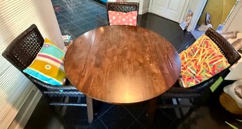 Round Wooden Dining Table With Three Woven Dark Brown Rattan And Wicker Dining Chairs