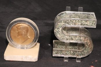 Dollar Sign With Shredded Bills, And JFK Inaugural Dollar In Plexiglass On Marble.