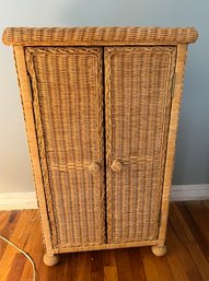 A Vintage Woven Wicker Cabinet With Double Doors And Rounded Feet