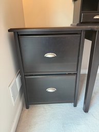 Two-drawer Vertical Wood Filing Cabinet In A Dark Brown Or Black Finish.