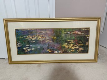 A Framed Print Of Monet's Water Lilies In An Ornate Gold Frame.