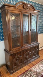 American Of Martinsville A Vintage Dark Wood China Cabinet With Glass Doors And Decorative Base.