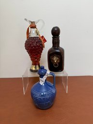 A Collection Of Three Decorative Wine And Spirit Bottles, Including A Grape Decanter And A Port Jug.
