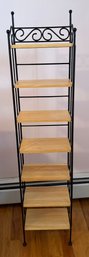 A Decorative Wrought Iron Shelving Unit With Five Blonde Wood Shelves
