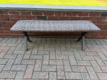 Gray Wicker Outdoor Bench With A Metal Frame.