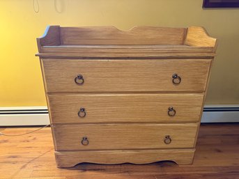 Light Wood Dresser With Four Drawers And A Raised Back Panel