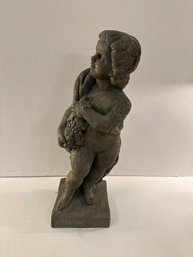 Resin Garden Statue Of A Reclining Putto Holding Grapes.
