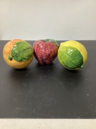 A Ceramic Orange, Red Apple, And Yellow Lemon, All Featuring Green Leaves
