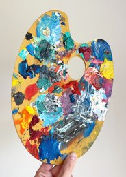 Wooden Hand-held Artist's Paint Palette Covered In Thick Colorful Paint. Working Palette.