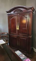 Carved Mahogany Armoire With Ornate Pediment And Brass Hardware