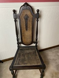 Stately Antique Black Wooden Chair With Cane Back And Seat And Intricate Carving