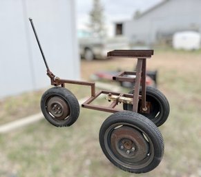 Custom-built, Three-wheeled Cart Featuring A Metal Frame And Rusted Steel Rims
