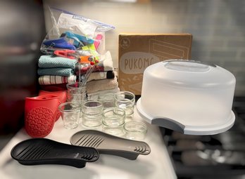 Assortment Of Kitchen Cookware Featuring Glass Ramekins, Panini Press, Hand Towels, Oven Mitts, Cake Server