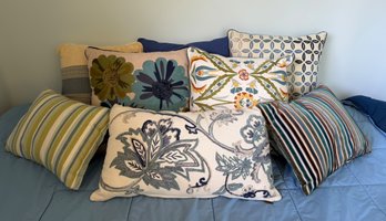 Assortment Of Colorful Throw Pillows Featuring Floral Prints, Striped Patterns, And Embroidery