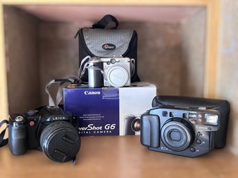 Photographers Collection Of Digital Cameras Featuring Leica V-lux, Canon G6 And Canon Sure Shot Zoom XL