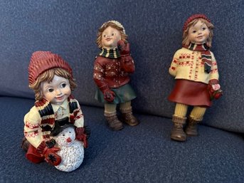 A Group Of Three Town Caroler Girl Figures