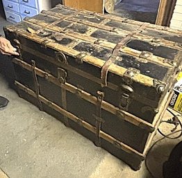 Antique Steamer Trunk Featuring Brass Hardware And Leather Strapping