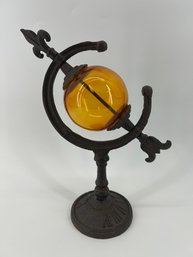 Amber Glass Globe Sundial Featuring A Cast Iron Stand