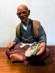 Vintage Hakata Mimasu Doll, Specifically A Japanese Clay Figure Depicting An Old Man Painting