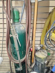 Three Bottles Of Gas And Connected Gauges And Hoses