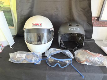 2 Racing Helmets And Several Packages Of Goggles