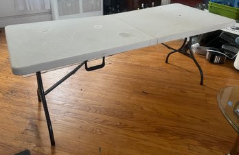 Durable Plastic Fold-in-half Utility Table With A Sturdy Steel Folding Frame