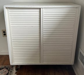 White Tambour Sliding-door Cabinet Features Classic Slatted Sliding Doors And Tapered Wooden Legs