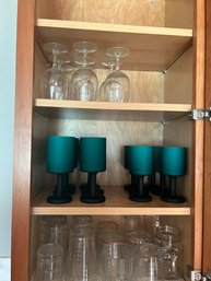 Lot 24- Contents Of Cabinet. Clear Drinking Glasses And Fun Wine Glasses