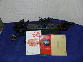 ATARI 2600 WITH CONTROLLERS AND PAPERWORK