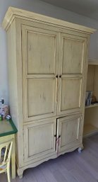 Vintage Distressed Wooden Armoire With Four Paneled Doors In Cream Finish.